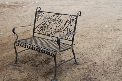 Wrought iron bench with dragonfly and flower motifs