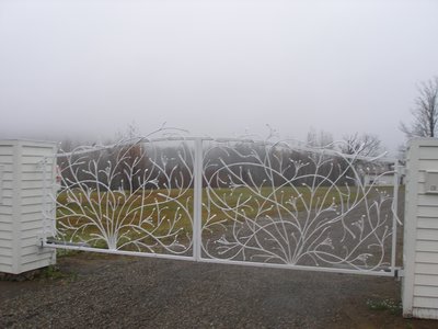 Large white wrought iron gate with tree and branch design