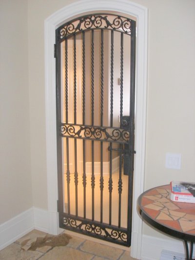 Wrought iron arched security gate with scrollwork
