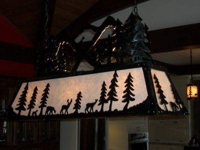 Wrought iron chandelier with forest and mountain scene, close-up
