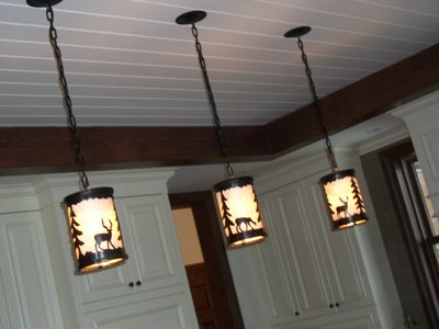 Wrought iron pendant lights with deer and pine tree silhouettes