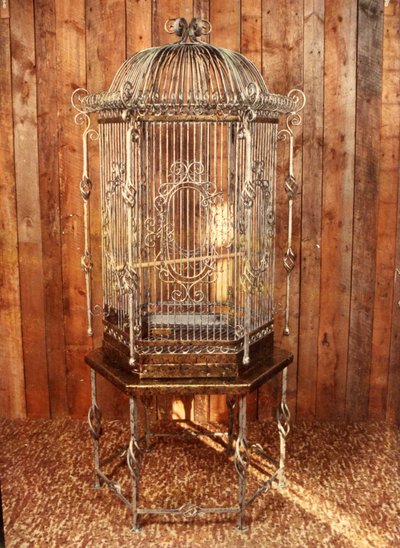 Ornate wrought iron aviary on pedestal