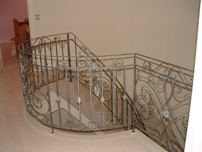 Curved wrought iron staircase railing with scrollwork, top view