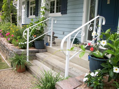 White wrought iron porch railing with scrollwork