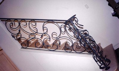Wrought iron staircase railing with flowing scrollwork